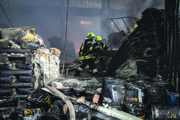 FIREFIGHTERS EXTINGUISH a fire in Podil warehouse in. Kyiv, after Russia launched more than 150 drones, missiles and aerial bombs at Ukraine, on Dec. 29, 2023. (Nicolas Cleuet/Le Pictorium Agency via Zuma Press/TNS)