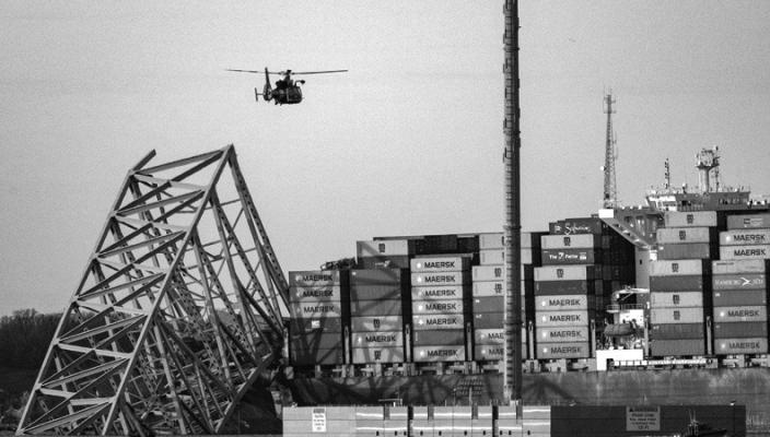 A COAST Guard helicopter flies over the Maersk container ship Dali and the remains of the collapsed Francis Scott Key Bridge. The massive container ship was adrift early Tuesday as it headed toward the iconic Francis Scott Key Bridge, losing power before colliding with one of the bridge’s support columns. (Jerry Jackson/Baltimore Sun/TNS)