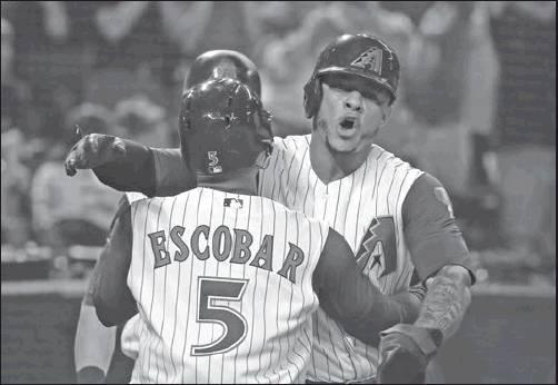 EDUARDO ESCOBAR (5) of the Arizona Diamondbacks celebrates his three-run home run against the Los Angeles Dodgers with Ketel Marte during the sixth inning of a baseball game Thursdayin Phoenix. (AP Photo)