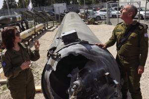 ISRAELI MILITARY spokesman Rear Admiral Daniel Hagari, right, and his deputy Masha Michelson pose next to an Iranian ballistic missile which fell in Israel on the weekend, during a media tour at the Julis military base near the southern Israeli city of Kiryat Malachi on April 16, 2024. (Gil Cohen-Magen/AFP/Getty Images/TNS)