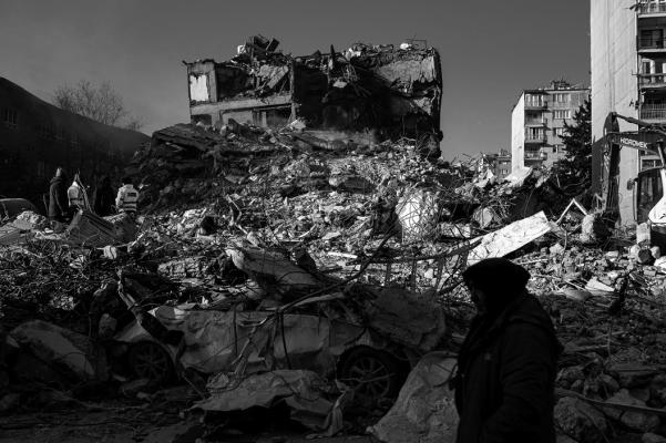 A woman walks by the rubble of a collapsed building in Hatay, on Feb. 10, 2023, four days after the 7.8 magnitude earthquake that killed over 11,200 people. (Yasin Akgul/ AFP/Getty Images/TNS)