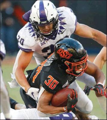 OKLAHOMA STATE running back Chuba Hubbard (30) is tackled by TCU linebacker Garret Wallow (30) and linebacker Ben Wilson (18) in the second half of an NCAA college football game in Stillwater, Okla., Saturday, Nov. 2, 2019. (AP Photo)