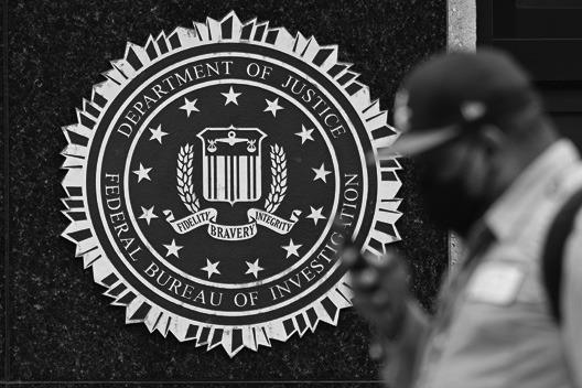 A PEDESTRIAN walks past a seal reading “Department of Justice Federal Bureau of Investigation”, displayed on the J. Edgar Hoover FBI building, in Washington, DC, on August 15, 2022. (MANDEL NGAN/AFP via Getty Images/TNS)