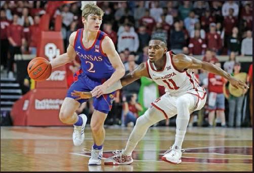 CHRISTIAN BRAUN (2) of Kansas is defended by Oklahoma’s De’Vion Harmon (11) during a college basketball game in Norman Tuesday. Kansas won the game 66-52. (AP Photo)