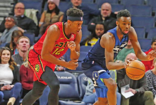 ANDRES WIGGINS of the Minnesota Timberwolves, right, and Atlanta Hawks&#x2019; De&#x2019;Andre Hunter chase the ball in the first half of an NBA game Wednesday in Minneapolis. Wiggens is one of those heading to a new team. (AP Photo)