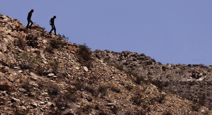SMUGGLERS TRAVERSE the rocky terrain along the Mexican side of the New Mexico/ Texas border. They study the terrain in hopes of moving migrants across the border, May 12, 2023. (Tom Fox/The Dallas Morning News/TNS)