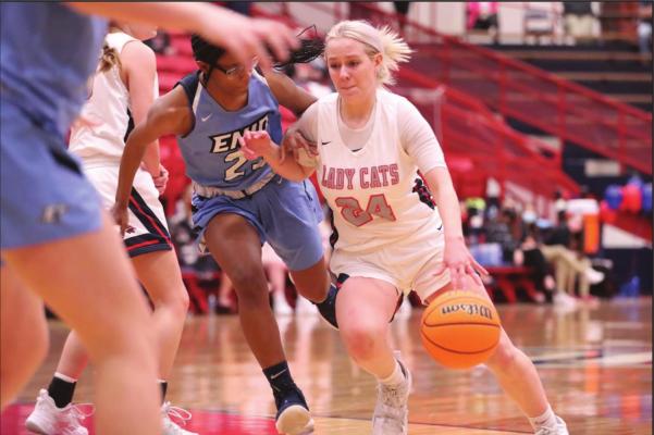 STARTING A drive through heavy traffic is Ponca City’s Ashlynn Fincher (24) during Tuesday’s game with Enid at Robson Field House. Fincher was the Ponca City’s leading scorer with 19 points. The Lady Cats won the game 67-29. This photo was provided by Larry Williams.