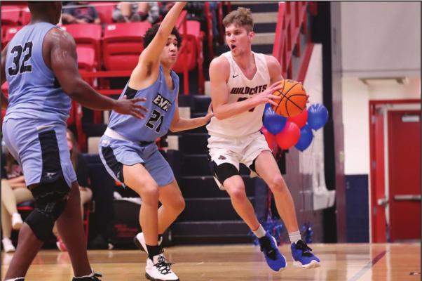 DRIVING THE baseline is Ponca City’s Steven Faulkner (white uniform) during a game Tuesday against Enid at Robson Field House. Faulkner was the Wildcats’ leading scorer with 14 points, but Enid won the game 61-47. This photo was provided by Larry Williams.