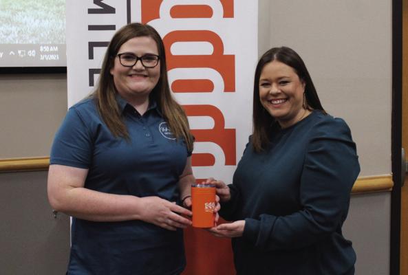 Kayla Blaes (left) was the speaker at 1 Million Cups on Wednesday, March 1. Here is Blaes being presented with an orange cup by Brook Lindsday (right), this cup is given to all speakers at the 1 Million Cups meeting. (Photo by Calley Lamar)