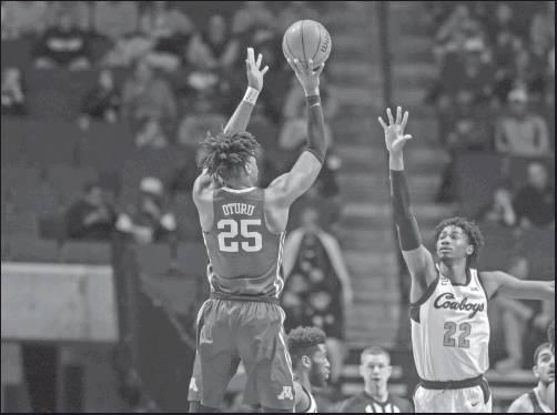 MINNESOTA CENTER Daniel Oturu shoots over Oklahoma State forward Kalib Boone during a college basketball game Saturday in Tulsa. Minnesota won 86-66, (AP Photo)