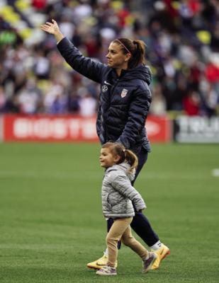 ALEX MORGAN (13) of the United States waves to the crowd with her daughter Charlie Carrasco following a game against Japan during the 2023 SheBelieves Cup at GEODIS Park on Feb. 19, 2023, in Nashville, Tennessee. (Andy Lyons/Getty Images/TNS)