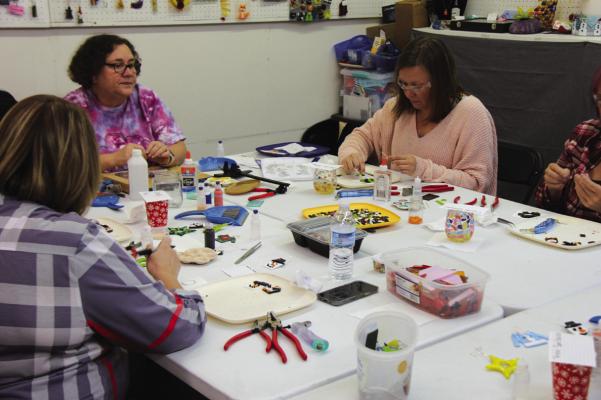 COMMUNITY MEMBERS enjoy a fun filled evening of holiday cheer during the last glass fusing class, held on Saturday, Nov. 18. (Photo by Dailyn Emery)