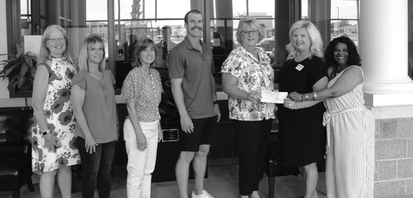 MEMBERS OF the 35th Leadership Ponca City Class were on site at the University Center to donate a $2000 scholarship for a non-traditional student on Thursday, July 20. Accepting the check for the scholarship is University Center CEO Robyn Armstrong (blue shirt) and Diane Anderson (furthest right). (Photo by Calley Lamar)