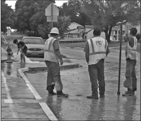 Father, daughter and son, Arthar Morris, Destinee Morris and Kadence Morris, played in the fire hydrant on north 7th St. as a city water crew worked diligently to repair the water main break that had occurred at the intersection of 5th and Hartford Ave. (News Photo provided by Laura Windom).