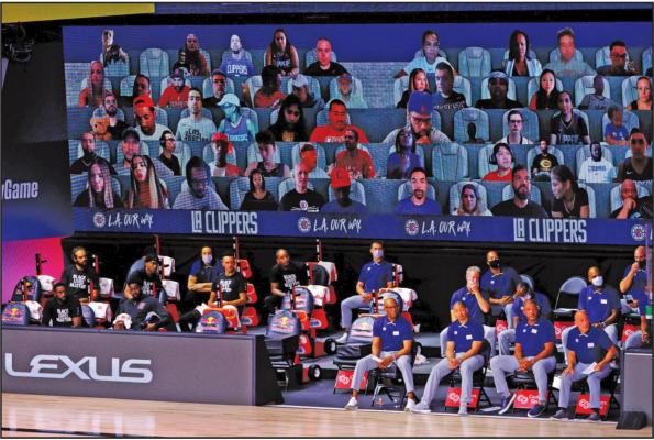 A view of the Los Angeles Clippers bench and fans on a screen during the game against the Phoenix Suns on August 4, 2020 at The Arena at ESPN Wide World of Sports Complex in Lake Buena Vista, Florida. (Kevin C. Cox/Getty Images/TNS)