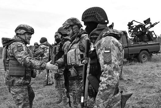 COMMANDER OF the Joint Forces of the Armed Forces of Ukraine, lieutenant general Serhiy Nayev, left, shakes hands with Ukrainian servicemen during an anti drone drill in Chernigiv region on Nov. 11, 2023. (Sergei Supinsky/AFP/Getty Images/TNS)