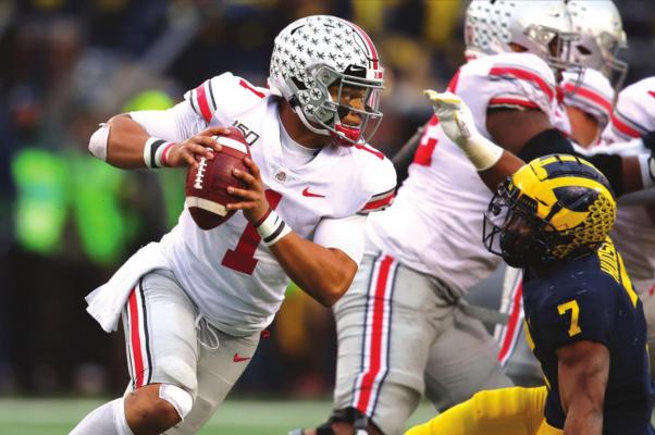In this file photo, Justin Fields (1) of the Ohio State Buckeyes tries to get around the tackle of Khaleke Hudson (7) of the Michigan Wolverines during the second half at Michigan Stadium on November 30, 2019 in Ann Arbor, MI. Fields was one of the proponents of restarting the Big Ten conference amind COVID-19 pandemic. (Gregory Shamus/Getty Images/TNS)