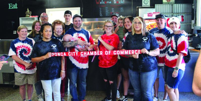 THE PONCA City Chamber of Commerce held a ribbon cutting ceremony for the grand re-opening of Snyder’s Chicken and Catering, located at 3151 W. North Ave., on Saturday, July 22. Cutting the ribbon is Courtney Primeaux. She is accompanied by family and co-workers. (Photo by Calley Lamar)
