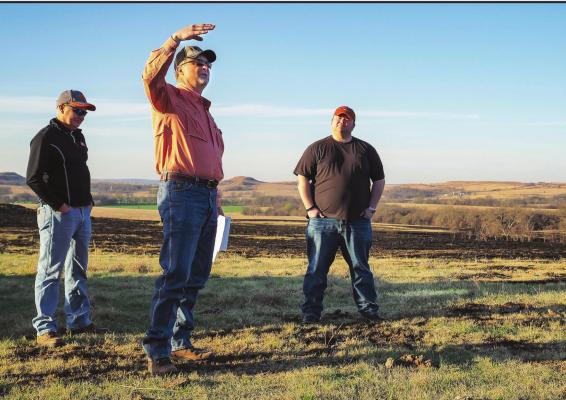 OSU EXTENSION Agricultural Educator Leland McDaniel (center, hand raised) explains the economic and environmental benefits of patch burning at demonstration plots during a multi-county cattle operation field tour. (Photo by Todd Johnson, OSU Agricultural Communications Services)