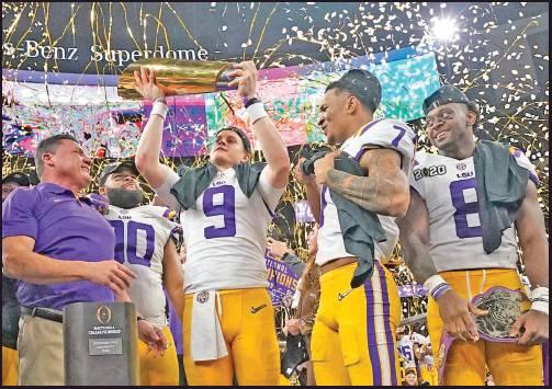 LSU QUARTERBACK Joe Burrow holds the trophy after this team’s win against Clemson in the College Football Playoff national championship game Monday in New Orleans. LSU won 42-25. (AP Photo)