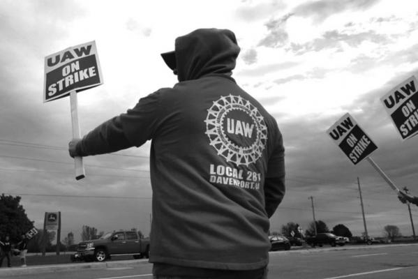 Striking workers picket outside of the John Deere Davenport Works facility on Oct. 15, 2021 in Davenport, Iowa. More than 10,000 John Deere employees, represented by the UAW, walked off the job yesterday after failing to agree to the terms of a new contract. (Scott Olson/Getty Images/TNS)