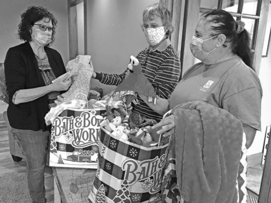 Living Hope Pregnancy Center Executive Director Famona Ash (left) accepts donations from Soroptimist members Sharon Millemon and Terri Buesing.