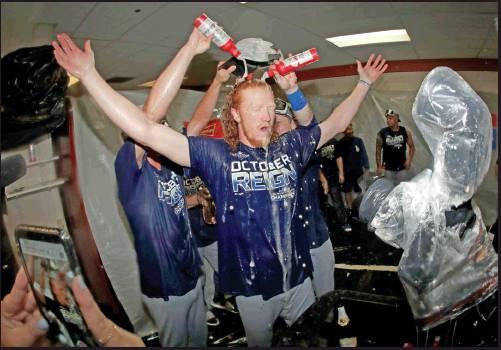 LOS ANGELES Dodgers pitcher Dustin May, center, is doused during a lockerroom celebration after the Dodgers defeated the Baltimore Orioles 7-3 in a baseball game Tuesday in Baltimore. The Dodgers clinched the NL West title. (AP Photo)