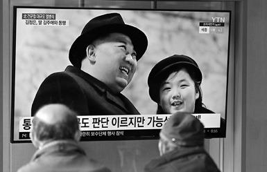 People watch a television screen showing a news broadcast with an image of North Korean leader Kim Jong Un (left) and his daughter presumed to be named Ju Ae (right) attending a military parade held in Pyongyang to mark the 75th founding anniversary of its armed forces, at a railway station in Seoul on Feb. 9, 2023. (Jung Yeon-Je/ AFP via Getty Images/TNS)