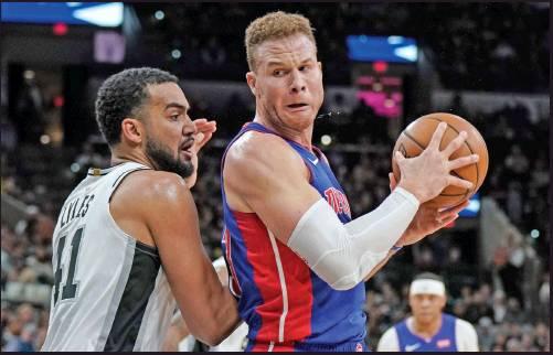 BLAKE GRIFFIN of the Detroit Pistons, right, drives against San Antonio Spurs’ Trey Lyles during an NBA game Saturday in San Antonio. Griffin, a former Oklahoma basketball player, will be sidelined indefinitely after knee surgery. (AP Photo)