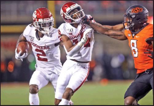 OKLAHOMA WIDE receiver CeeDee Lamb (2) runs after a catch while wide receiver Lee Morris (84) blocks Oklahoma State cornerback Rodarius Williams (8) during a game Saturda in Stillwater. After defeating the Cowboys 34-16, the Sooners will meet the Baylor Bears Saturday in the Big 12 Championship game in Arlington, Tex. (AP Photo)