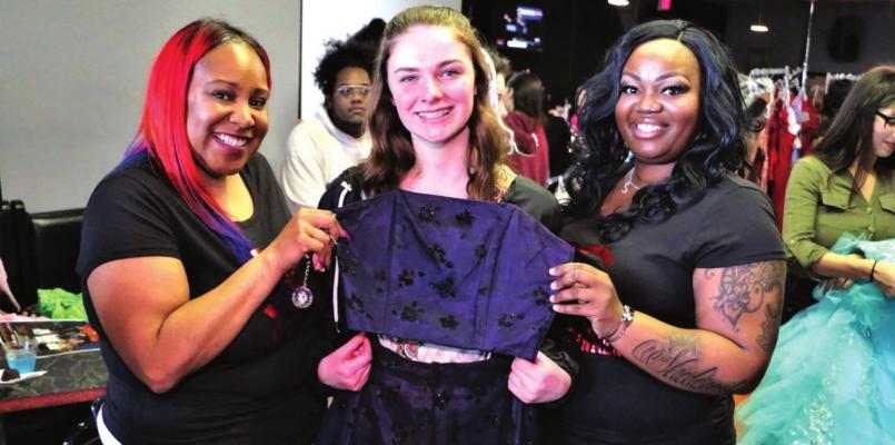 An excited prom-goer (center) poses with her new dress alongside CEO of Candy Girl Entertainment Shalonda Lewis (right) and her associate at Say Yes to the Prom Dress 2020. Photo provided by Shalonda Lewis