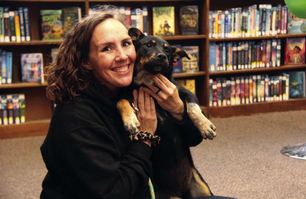 ACO 120 Parson poses with one of their available pups, Aurora, at the Blackwell Public Library during their recent adoption event. (Photo by Dailyn Emery)