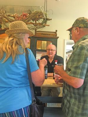 Winery owner Bob Wickizer helps Ponca Citians Ellen and Lee Cobb select wines to taste at the Pecan Creek Winery in Muskogee.