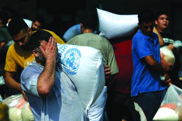PALESTINIANS STORM a U.N.-run aid supply center that distributes food to displaced families following Israel’s call for more than 1 million residents in northern Gaza to move south for their safety, in Deir al-Balah on Oct. 28, 2023. (Mohammed Abed/AFP/Getty Images/TNS)