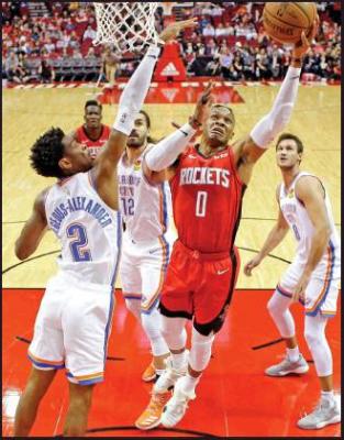 HOUSTON ROCKETS guard Russell Westbrook (0) drives to the basket as Oklahoma City Thunder guard Shai Gilgeous-Alexander (2) defends during an NBA game, Monday in Houston. The Rockets won 116-112. (AP Photo)
