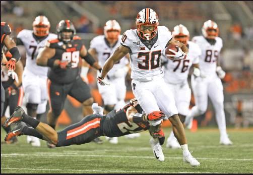 OKLAHOMA STATE running back Chuba Hubbard (30) is brought down by Oregon State defensive back David Morris (24) during the first half of an game in Corvallis, Ore., Aug. 30. The Cowboys are back in action 6 p.m. Saturday against McNeese. Hubbard is the national leader in rushing. (AP Photo)