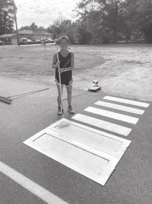 Adair County OSU Extension Educator Jessie Garcia paints a crosswalk in the Westville Public School District as part of a project to lower obesity rates among school-age children. (Photo provided)