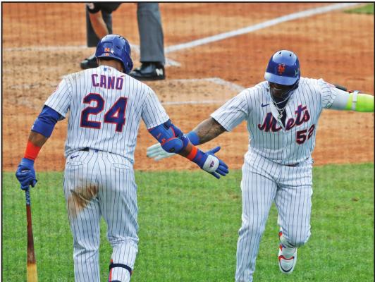 NEW YORK Mets’ Yoenis Cespedes, right, celebrates his solo home run with Robinson Cano (24) during the seventh inning of a baseball game against the Atlanta Braves at Citi Field, Friday, July 24, 2020, in New York. (AP Photo/Seth Wenig)