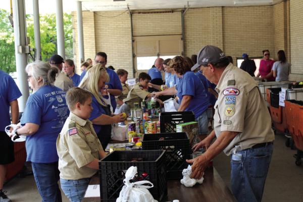 MANY VOLUNTEERS, including scouts, came out to assist in the Letter Carrier Food Drive during the United Way Day of Caring. (Photo by Calley Lamar)