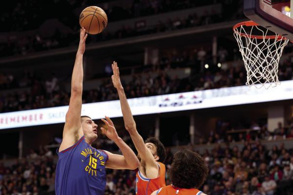 THE DENVER Nuggets’ Nikola Jokic (15) puts up a shot over the Oklahoma City Thunder’s Chet Holmgren in the first quarter at Ball Arena on Saturday, Dec. 16, 2023, in Denver. (Matthew Stockman/ Getty Images/TNS)