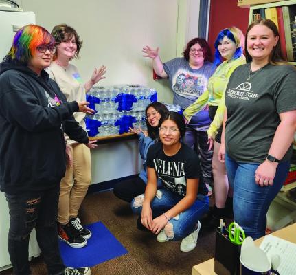 Cherokee Strip Credit Union donated bottled water to Wildcat Academy students. Shown standing, from left: Allie leClair, Jaclyn Stevenson, Kiera Jones, Chloe Parks and Brittney Swain from Cherokee Strip. Kneeling are Anna Howe and Autumn Pettit. (Photo Provided)