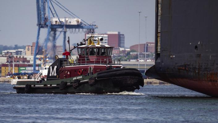 THE TUG April Moran escorts the Carmen vehicle carrier through the new temporary channel at the Francis Scott Key Bridge collapse site. (Jerry Jackson/The Baltimore Sun/TNS)