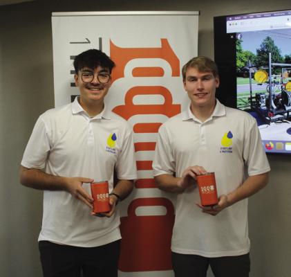 ROMAN BINTZ (left) and Brian Fredericks (right) spoke at the 1 Million Cups meeting at Pioneer Technology Center to discuss their business, 2 Guys &amp; a Water Gun. They were both presented with orange cups gifted to speakers at the 1 Million Cups gatherings. (Photo by Calley Lamar)
