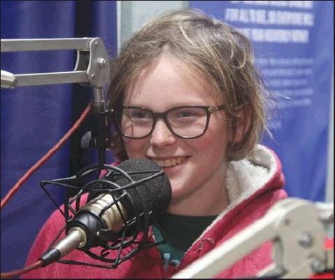 KAYLENA CHRISTIAN talks into the microphone while on the air at Kid DJ Day.