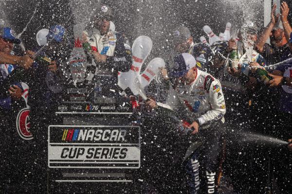 WILLIAM BYRON, driver of the (24) Valvoline Chevrolet, and crew celebrate by spraying champagne in victory lane after winning the NASCAR Cup Series Go Bowling at The Glen at Watkins Glen International on Aug. 20, 2023, in Watkins Glen, New York. (Chris Graythen/ Getty Images/TNS)