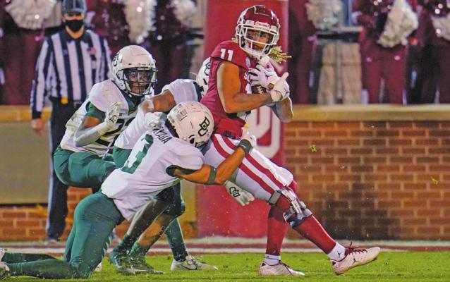 Oklahoma wide receiver Jadon Haselwood (11) is tackled by Baylor cornerback Raleigh Texada (3) during the second half of an NCAA college football game Saturday, Dec. 5, 2020, in Norman, Okla. (AP Photo/Sue Ogrocki)