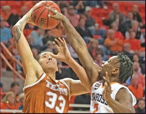 OKLAHOMA STATE guard Chris Harris Jr. (2) attempts to block a dunk by Texas forward Kamaka Hepa (33) during a college basketball game in Stillwater Wednesday. Texas won the game 76-64. (AP Photo)