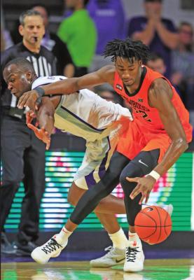 OKLAHOMA STATE forward Kalib Boone (22) spins away from Kansas State forward Makol Mawien, left, during a college basketball game in Manhattan, Kan., Tuesday. Oklahoma State defeated Kansas State 64-59. (AP Photo)