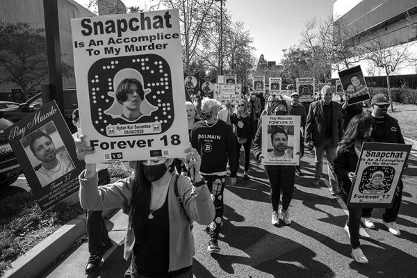 Family and friends of people who died after taking pills with fentanyl, hold signs as they protest against illicit drug availability to children on the app Snapchat near the Snap, Inc. headquarters, in Santa Monica, Californiaon Jan. 21, 2022. (Apu Gomes/AFP via Getty Images/TNS)