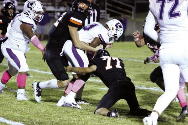 DOMINIC GREIN (12) and Dalton Pierce (77) tackle a Hominy runner at the line of scrimmage. (Photo by Melissa Swords)